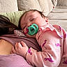Paisley Rae is registered to the contest to win money with this photo: baby, pacifier, sleeping, pink_clothing, flamingo_pattern, couch, cushion, indoor, person, hand, face, child, resting, cozy, closeup, comfort, soft_fabric, casual, relaxation, home