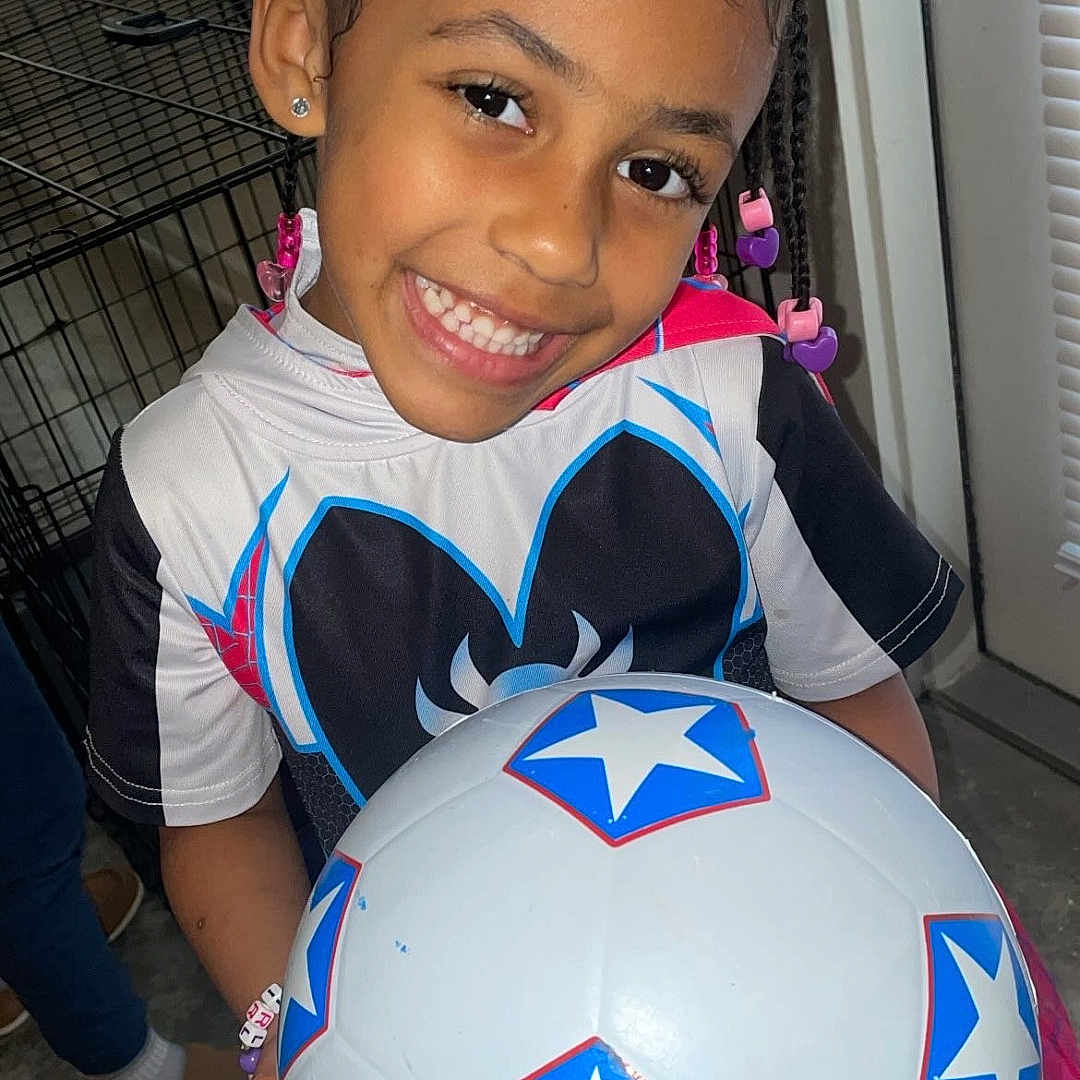 Memory Mae joined the competition — help win amazing prizes! ball, bodypart, child, clothing, costume, face, female, football, footwear, girl, head, person, photography, portrait, shoe, soccer, soccerball, sphere, sport, t_shirt