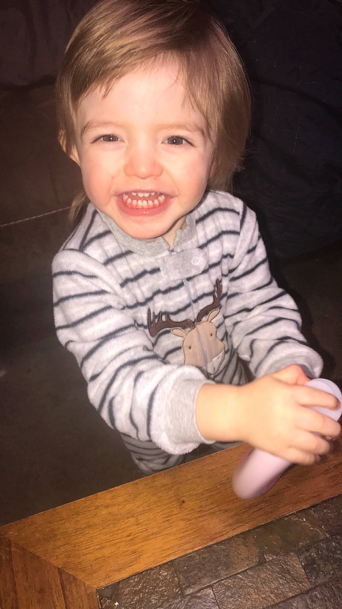 Connor is registered to the contest to win money with this photo: baby, baby_toddler_clothing, cheek, face, finger, flash_photography, floor, flooring, fun, gesture, happy, hardwood, nose, person, sitting, sleeve, smile, t_shirt, thumb, toddler