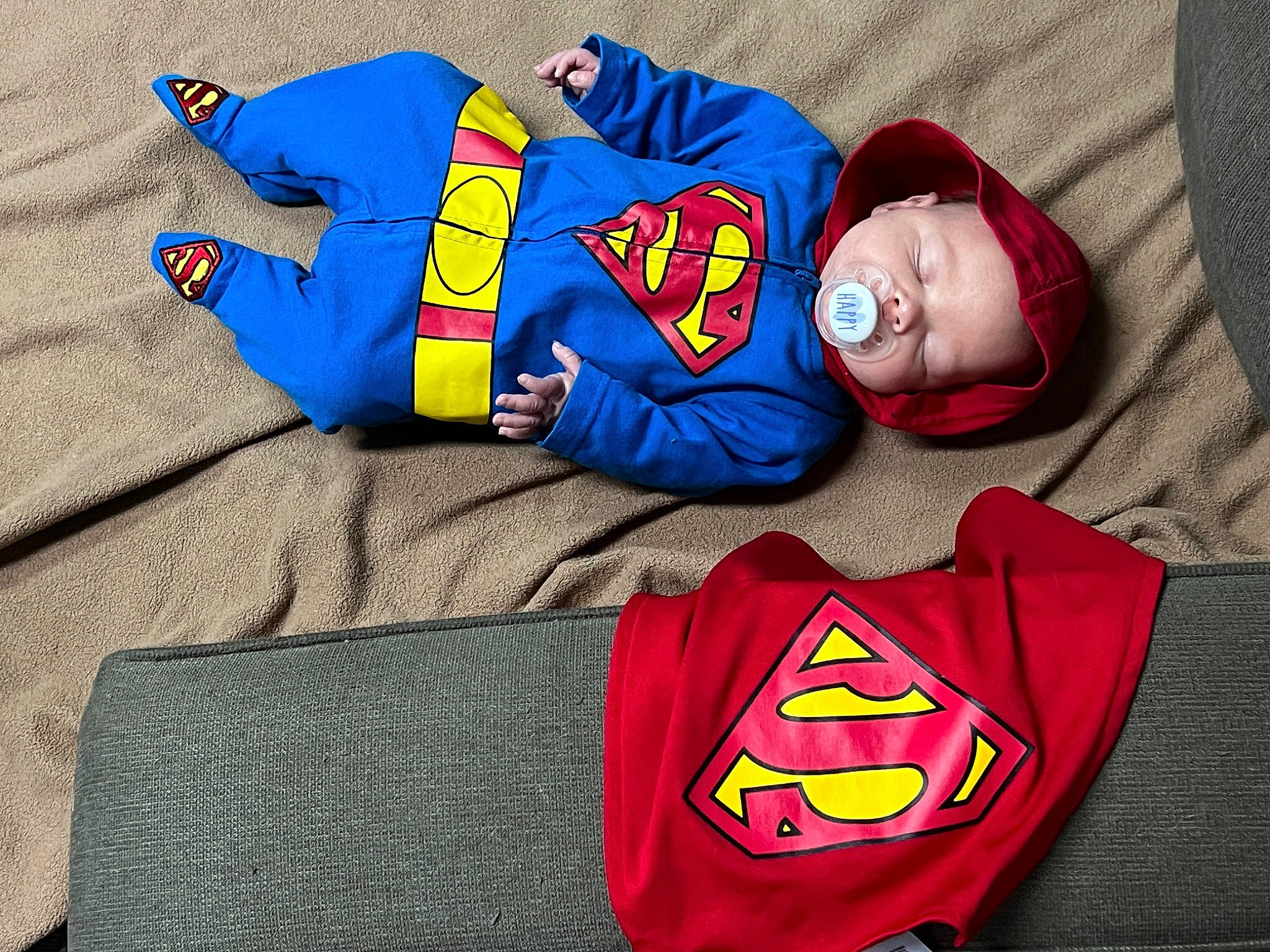 Warren is registered to the contest to win money with this photo: baby_toddler_clothing, blue, carmine, child, comfort, costume, electric_blue, fictional_character, justice_league, linens, orange, pajamas, person, red, room, sleeve, smile, sportswear, t_shirt, toddler