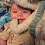 baby, smiling, blanket, soft_toy, tshirt, infant, cute, happy, face, child, cozy, pattern, fabric, portrait, person, closeup, indoor, comfort, playful, sleepwear