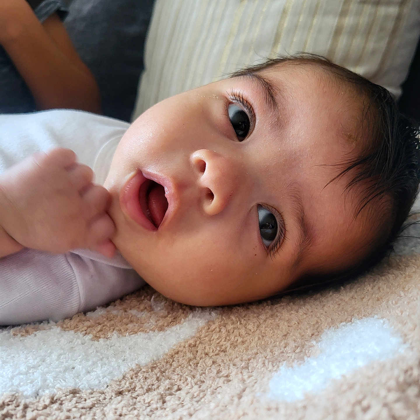Olivia joined the competition — help win amazing prizes! baby, carpet, child, closeup, comfort, cozy, curious, expression, eyes, face, hair, hand, indoors, infant, lying_down, mouth, person, pillow, skin, soft_texture