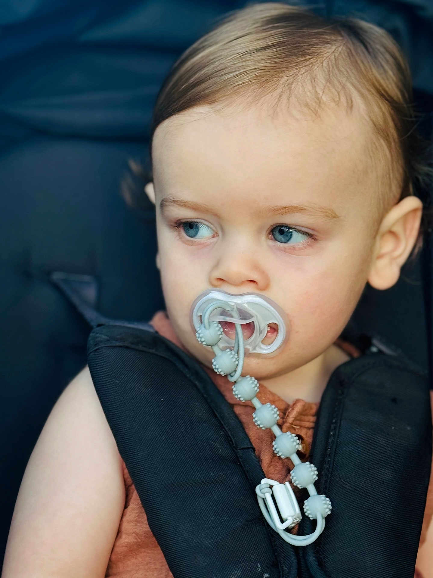 Hudson joined the competition — help win amazing prizes! toddler, child, pacifier, car_seat, blue_eyes, face, hair, clothing, baby, person, seatbelt, beads, closeup, portrait, looking_away, infant, young_child, safety, cute, expression