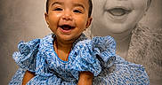 Avika is registered to the contest to win money with this photo: baby, child, smiling, portrait, dress, blue_dress, frilly, happy, cute, sitting, studio, photography, bracelet, infant, face, expression, background, monochrome, double_exposure, artistic