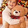 Ruby Shouk participe au concours pour gagner de l'argent avec cette photo : child, boy, smiling, teddy_bear, hugging, sweater, white_sweater, christmas_tree, holiday, festive, red_bow, plush_toy, indoors, happy, portrait, decorations, lights, celebration, seasonal, warmth