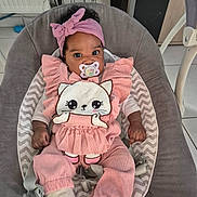 Haïly a rejoint le concours — aidez-le/la à gagner de superbes lots ! baby, infant, pacifier, pink_clothing, headband, baby_seat, cute, indoors, child, toddler, soft_toys, patterned_socks, relaxed, adorable, person, smiling_eyes, furniture, home, comfort, portrait