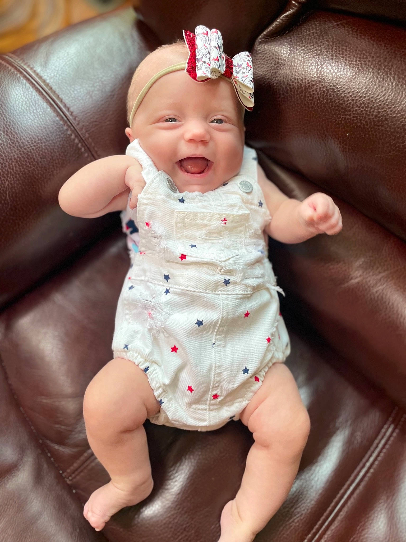 London is registered to the contest to win money with this photo: arm, baby, baby_toddler_clothing, cap, cheek, comfort, dress, eye, face, facial_expression, finger, hand, head, headwear, human_body, lip, mouth, person, pink, skin