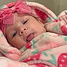 Bianca Rose joined the competition — help win amazing prizes! baby, infant, child, portrait, lying_down, blanket, pink, hood, bow, unicorn, plush_toy, bed, cozy, indoor, face, eyes, smiling, sitting, textile, photography