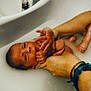 adult_hand, baby, bath, bath_time, bathtub, care, closeup, cute, family, hand, indoor, infant, milky_water, newborn, person, relaxation, skin, supporting_hand, tenderness, water