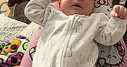 Bentley joined the competition — help win amazing prizes! baby, infant, onesie, animal_print, person, pink_pajamas, hello_kitty, living_room, furniture, blanket, clothing, footwear, smile, relaxing, indoor, home, table, bottle, couch, cozy