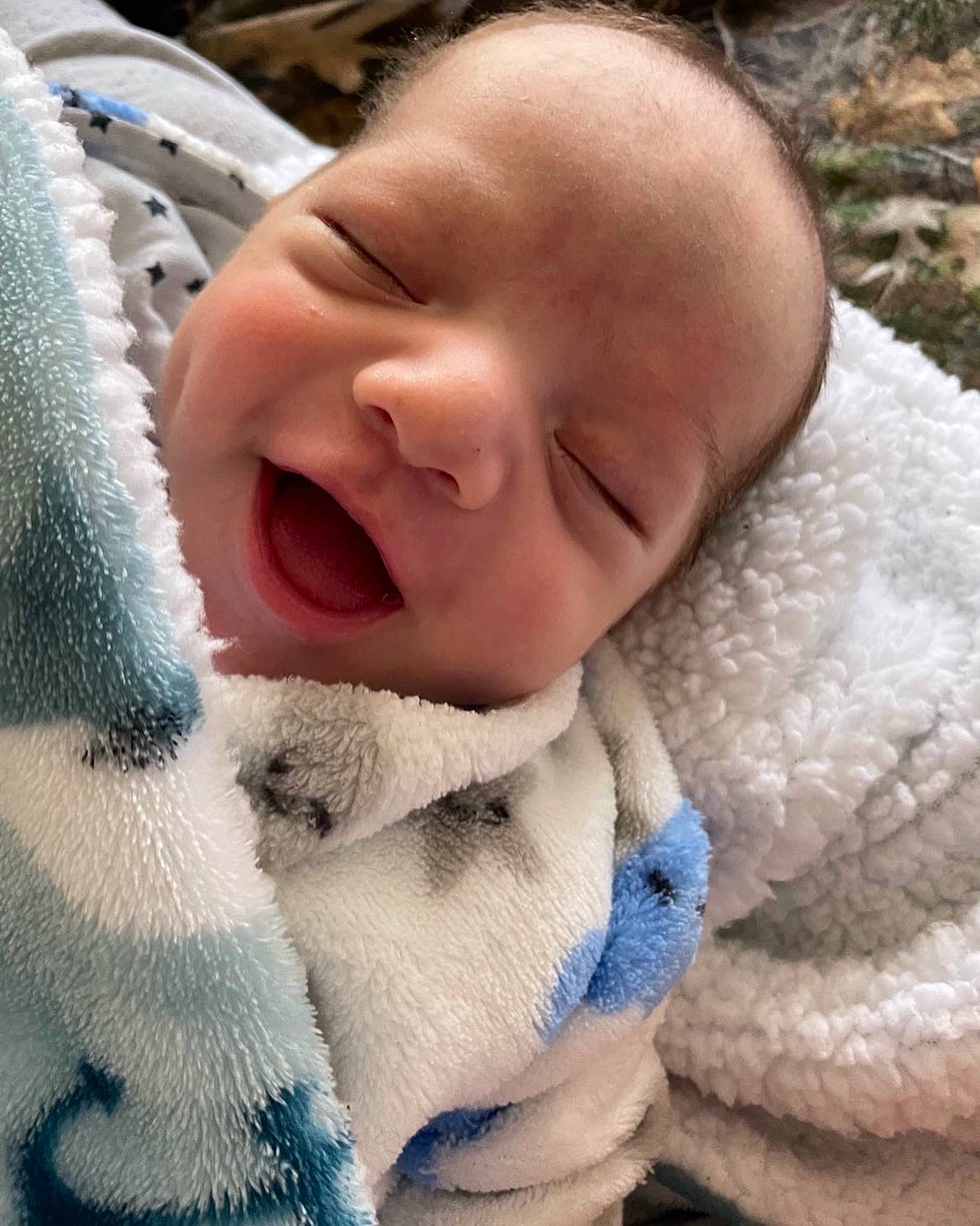 Elias is registered to the contest to win money with this photo: baby, cheek, child, close_up, comfort, eye, face, fur, grass, happy, head, linens, mammal, nose, person, skin, smile, textile, toddler, vertebrate