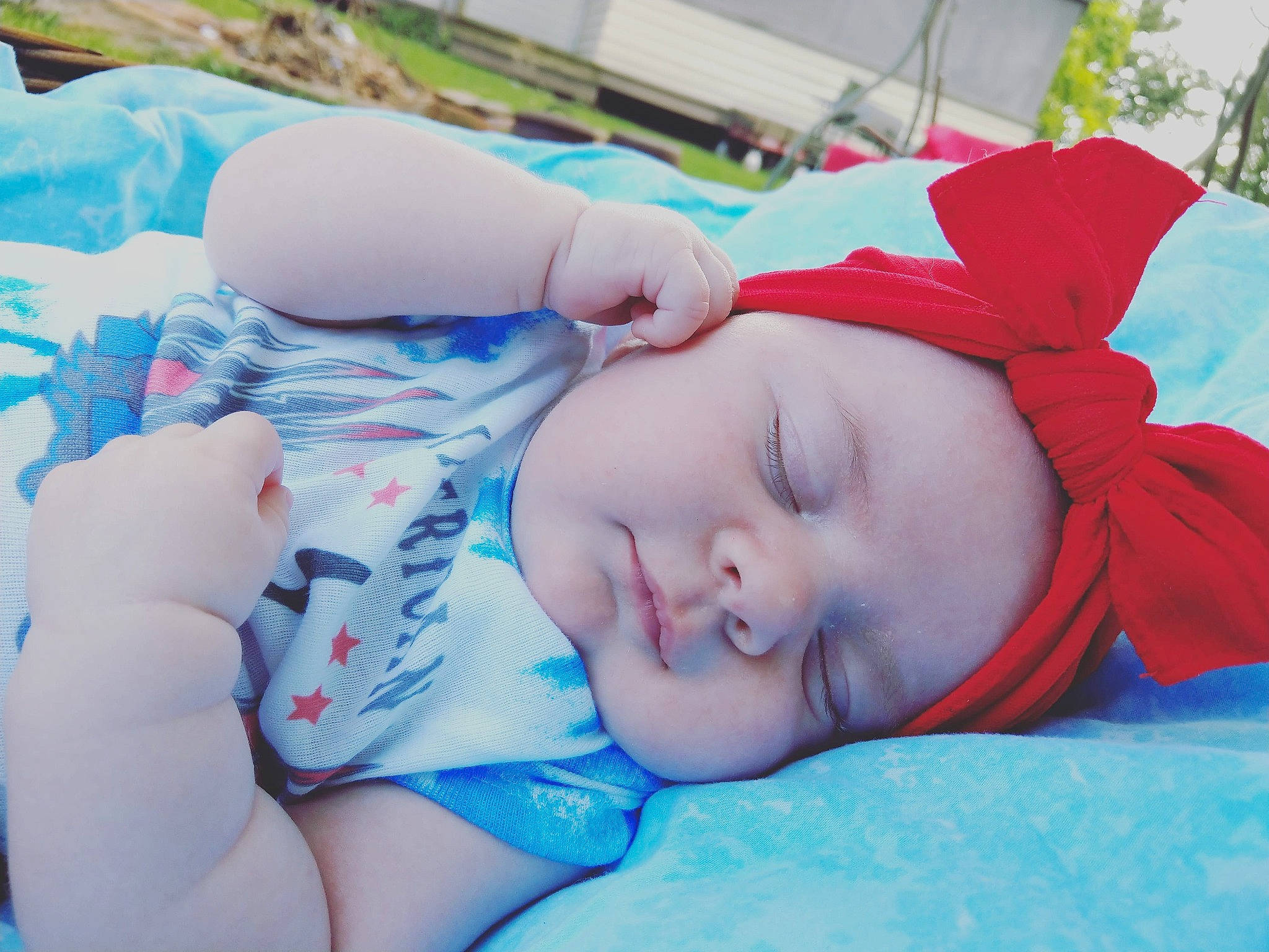Harlowe is registered to the contest to win money with this photo: azure, baby, baby_sleeping, baby_toddler_clothing, cap, comfort, eye, grass, happy, head, headgear, headwear, human_body, lip, mouth, nose, person, plant, skin, textile