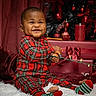Kingston is registered to the contest to win money with this photo: baby, child, smiling, plaid_pajamas, christmas_lights, holiday, presents, red, decorations, candle, christmas_tree, ribbon, festive, indoor, celebration, happy, cute, sitting, cozy, toy