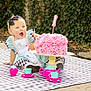 baby, child, girl, cake, pink, birthday, number_one, tea_set, outdoor, picnic_blanket, dress, headband, black_bow, happy, celebration, food, party, toy, smile, face