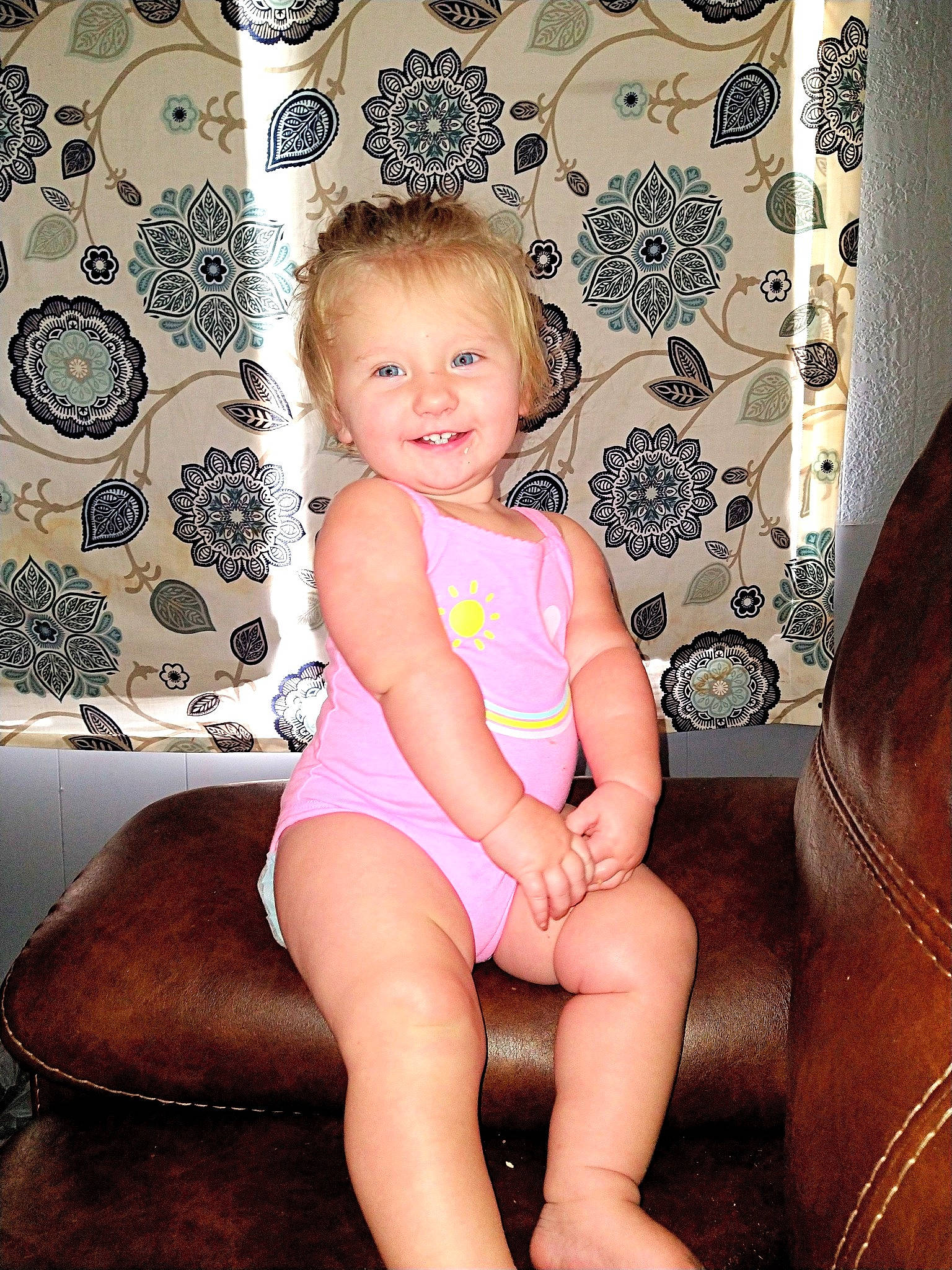 Athena is registered to the contest to win money with this photo: baby_toddler_clothing, cheek, finger, hairstyle, happy, human_leg, iris, joy, knee, leg, lip, organ, pattern, person, pink, shorts, skin, smile, textile, thigh