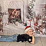 Naël participe au concours pour gagner de l'argent avec cette photo : child, smiling, santa_hat, jeans, black_tshirt, floor, tile, christmas_backdrop, fireplace, presents, christmas_tree, holiday, festive, decorations, indoor, pose, young_child, happy, celebration, seasonal