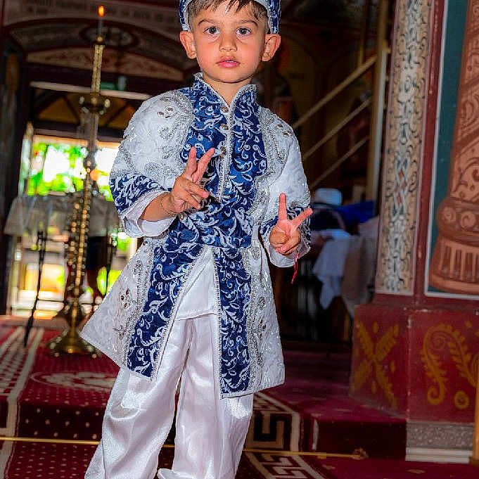 Annaser a rejoint le concours — aidez-le/la à gagner de superbes lots ! architecture, boy, carpet, celebration, child, colorful, costume, cultural, decorative, expression, hat, indoor, pattern, peace_sign, person, portrait, shoes, standing, traditional_clothing, young