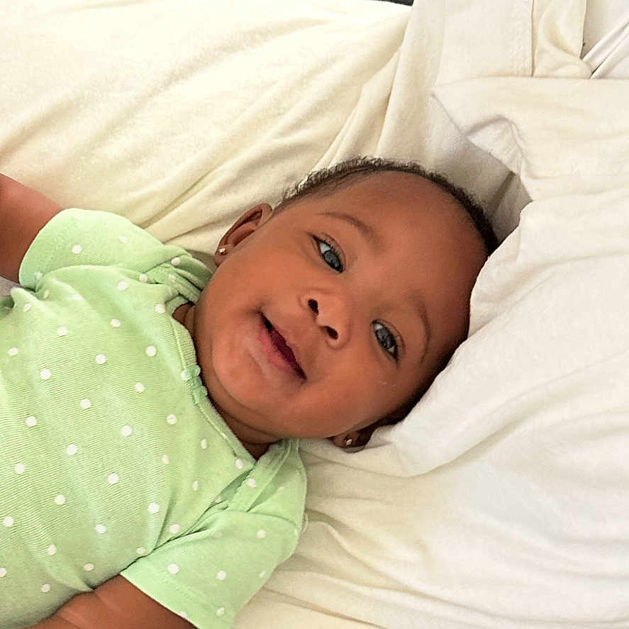 Ivionna is registered to the contest to win money with this photo: baby, infant, child, lying_down, green_onesie, polka_dot, blanket, play_mat, elephant_pattern, geometric_shapes, happy, smiling, indoors, cozy, soft_fabric, cute, portrait, young_child, comfortable, relaxed