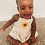child, toddler, baby, smiling, sunflower_dress, sitting, carpet, anklet, hair_bows, happy, indoors, portrait, toes, cute, skin_tone, laughing, floor, wall, arm, hands