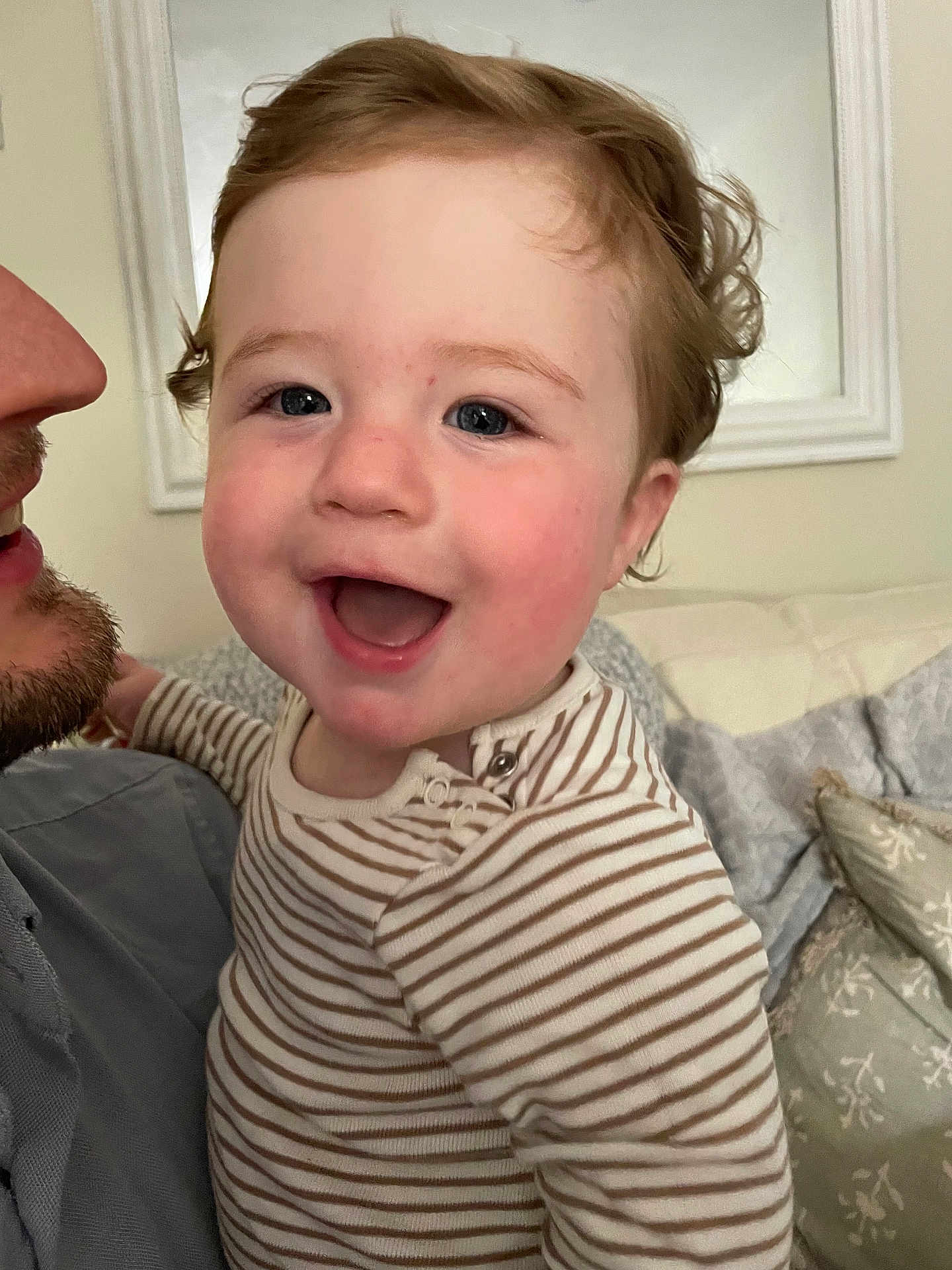 Wilfred joined the competition — help win amazing prizes! child, toddler, smiling, indoor, person, curly_hair, striped_clothing, adult, face, happy, couch, pillow, cozy, portrait, closeup, family, home, cute, infant, joy