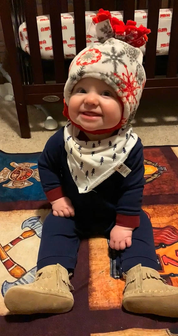 Rush is registered to the contest to win money with this photo: baby, baby_toddler_clothing, beanie, cap, carmine, cheek, child, costume, costume_hat, fictional_character, flooring, fun, happy, headwear, joy, knit_cap, laugh, pattern, person, sitting