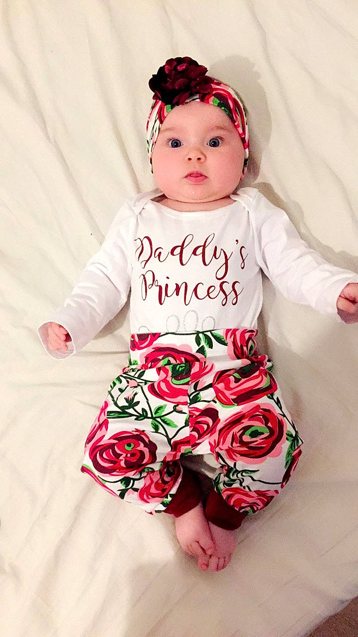 Mila participe au concours pour gagner de l'argent avec cette photo : baby, baby_bloomers, baby_products, baby_toddler_clothing, child, child_model, clothing, design, dress, hair_accessory, headgear, headpiece, outerwear, pattern, person, pink, plant, product, sleeve, toddler