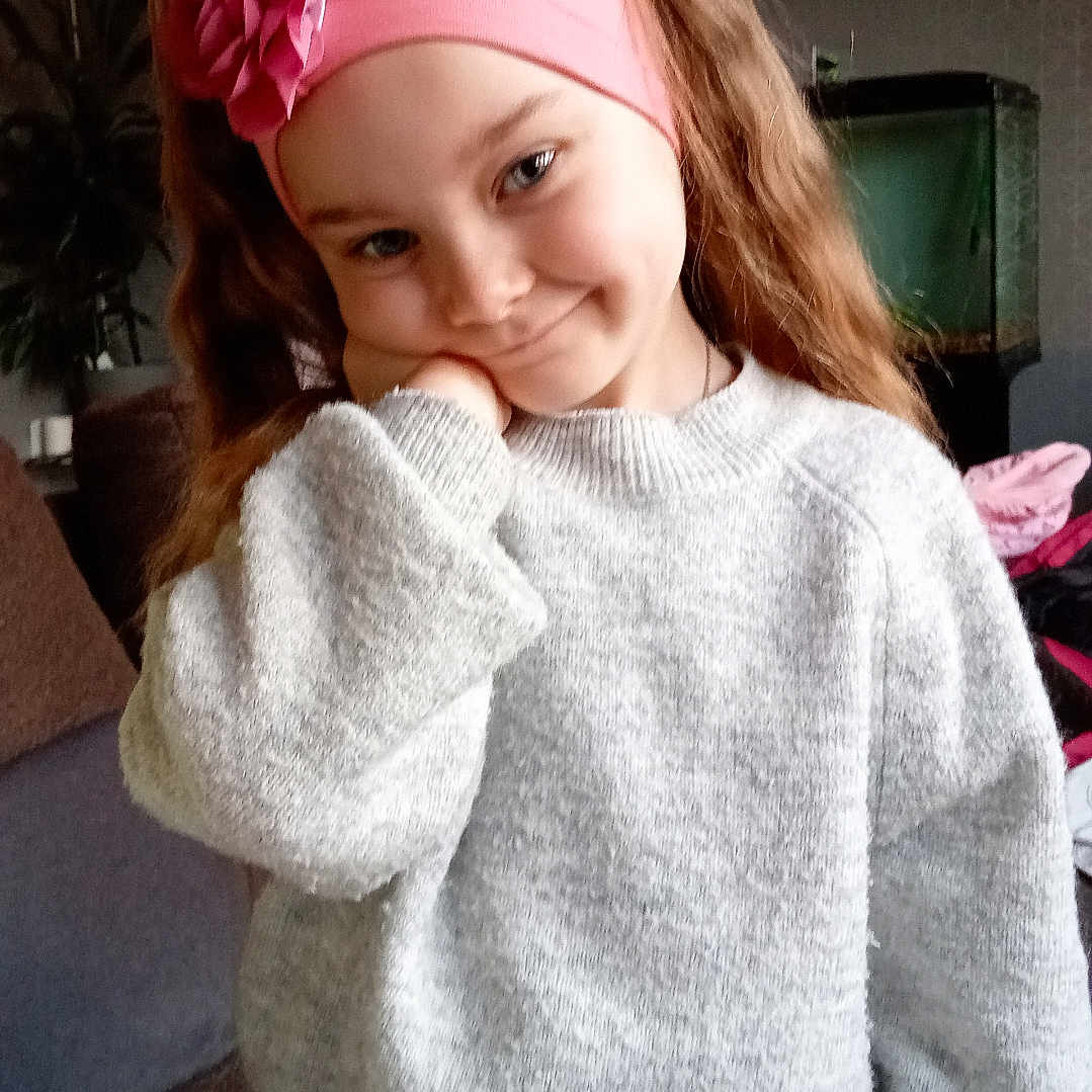 Mila participe au concours pour gagner de l'argent avec cette photo : accessories, blouse, child, clothing, couch, face, female, furniture, girl, hat, head, hoodie, knitwear, longsleeve, person, photography, portrait, sleeve, sweater, sweatshirt