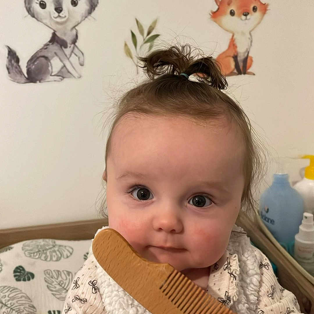 Youna participe au concours pour gagner de l'argent avec cette photo : animal_wall_stickers, baby, baby_girl, child, clothing, comb, curly_hair, cute, expression, face, fox, hand, indoor, infant, patterned_shirt, portrait, soft_lighting, wall_decor, wolf, wooden_comb