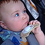Lewis is registered to the contest to win money with this photo: baby, child, blue_eyes, teething_toy, car_seat, warning_label, hand, face, clothing, seatbelt, close_up, infant, cute, young_child, indoors, portrait, skin, hair, expression, safety