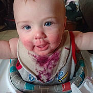 Lewis joined the competition — help win amazing prizes! baby, bib, blue_eyes, child, face, food_stain, high_chair, indoor, messy, person, plastic_toy, purple_stain, smiling, table, toddler, toy, wearing_clothes, white_skin, young_child, infant