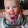 baby, bib, blue_eyes, child, face, food_stain, high_chair, indoor, messy, person, plastic_toy, purple_stain, smiling, table, toddler, toy, wearing_clothes, white_skin, young_child, infant