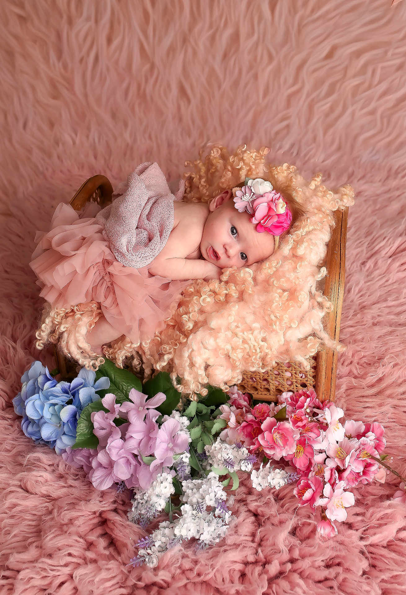 Kaylynn is registered to the contest to win money with this photo: baby, infant, pink, blanket, basket, flowers, headband, flower_crown, curly_hair, soft_texture, pastel_colors, portrait, cute, resting, indoor, decor, tulle_skirt, floral_arrangement, newborn, cozy