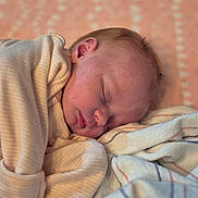 Kaylynn is registered to the contest to win money with this photo: baby, blanket, child, closeup, comfort, cozy, face, head, indoors, infant, newborn, peaceful, portrait, resting, skin, sleeping, soft_texture, striped_clothing, toddler, warm
