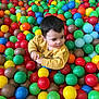 Milo a rejoint le concours — aidez-le/la à gagner de superbes lots ! child, toddler, ball_pit, colorful, plastic_balls, yellow_sweater, playful, indoor, fun, smiling, cute, face, short_hair, bright_colors, leisure, recreation, young_child, happy, casual_clothing, entertainment