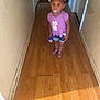 Ahlani joined the competition — help win amazing prizes! blurry, bottle, casual_clothing, cat_design, child, dim_lighting, floor, footwear, hair_bows, hallway, indoor, pacifier, person, purple_shirt, sandals, shorts, standing, walls, wood_floor, young_child