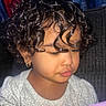 Jasmeen joined the competition — help win amazing prizes! toddler, child, curly_hair, earring, portrait, closeup, indoor, soft_lighting, thoughtful, face, skin, clothing, white_shirt, patterned_shirt, young_child, person, cute, baby, glowing_object, purple_light