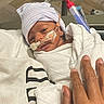 Treyvion is registered to the contest to win money with this photo: baby, bed, blanket, care, closeup, cute, hand, hat, healthcare, hospital, hospital_room, infant, medical, nasal_tube, newborn, patient, person, resting, small, wrapped