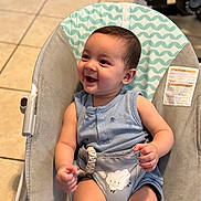Santiago joined the competition — help win amazing prizes! baby, child, smiling, happy, onesie, baby_chair, seat, indoor, floor, tile_floor, pattern, infant, cute, small_child, young_child, clothing, happy_face, sitting, playful, person