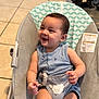baby, child, smiling, happy, onesie, baby_chair, seat, indoor, floor, tile_floor, pattern, infant, cute, small_child, young_child, clothing, happy_face, sitting, playful, person