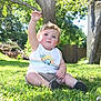 Timothy joined the competition — help win amazing prizes! child, toddler, grass, outdoor, sunlight, tree, greenery, summer, sitting, tank_top, shorts, barefoot, nature, yard, fence, playful, arm_raised, daylight, casual, cute