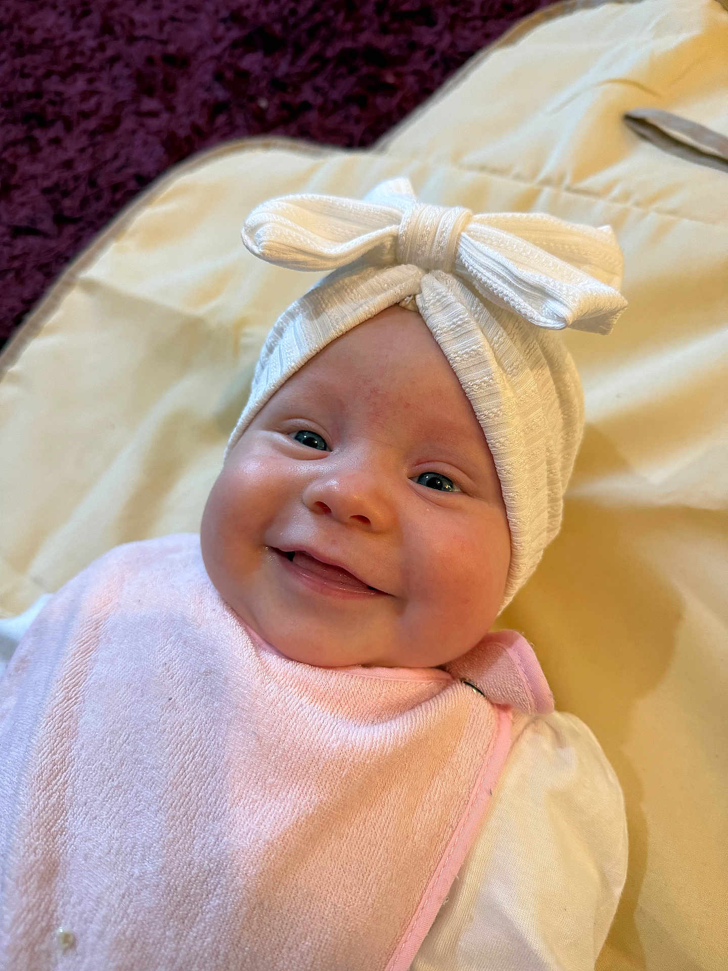 Ruby joined the competition — help win amazing prizes! baby, smile, headband, bow, pink_bib, blanket, infant, cute, face, child, soft, happy, lying_down, indoors, portrait, clothing, toddler, closeup, skin, young