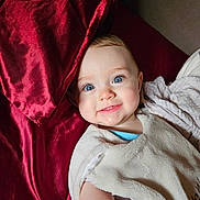Nora participe au concours pour gagner de l'argent avec cette photo : baby, blanket, blue_eyes, child, couch, cute, facial_expression, happy, infant, indoors, light_skin, pillow, portrait, red_pillow, smile, soft_texture, toddler, white_blanket, young_child, lying_down