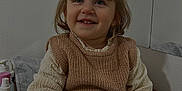 Elena a rejoint le concours — aidez-le/la à gagner de superbes lots ! toddler, child, girl, pigtails, bangs, smile, teeth, knit_vest, sweater, sitting, indoor, changing_mat, skincare_bottles, hand, cheeks, eyes, hair_tie, portrait, wall, cozy