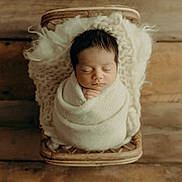 Lorenzo joined the competition — help win amazing prizes! newborn, baby, sleeping, wrapped, blanket, wicker_basket, wooden_floor, cozy, peaceful, infant, soft_texture, portrait, indoors, cute, child, resting, closeup, warm_tones, head, hands