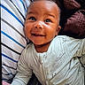 Ahlegend is registered to the contest to win money with this photo: baby, bed, bedding, blanket, child, close_up, clothing, eyes, face, happy, home, indoor, infant, lying_down, onesie, photography, pillow, portrait, sitting, smiling