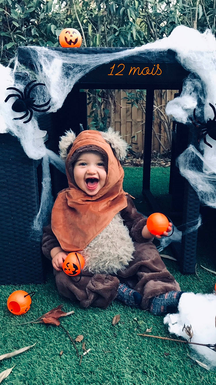 Kenzo a rejoint le concours — aidez-le/la à gagner de superbes lots ! advertising, baby, calabaza, event, fun, fur, grass, green, happy, headwear, illustration, leisure, person, photo_caption, plant, pumpkin, smile, toddler, tree, trick_or_treat