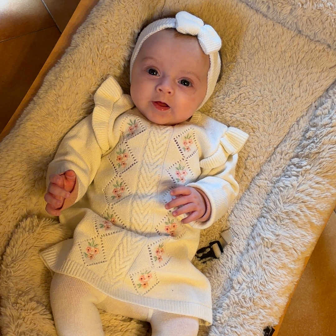 Emie participe au concours pour gagner de l'argent avec cette photo : baby, blanket, child, comfort, cozy, cushion, cute, feet, floor_tiles, floral_pattern, hands, headband, indoor, infant, knitwear, portrait, relaxing, smiling, soft_texture, warm_colors