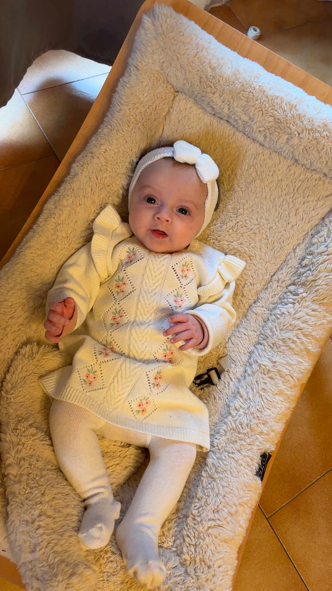 Emie participe au concours pour gagner de l'argent avec cette photo : baby, blanket, child, comfort, cozy, cushion, cute, feet, floor_tiles, floral_pattern, hands, headband, indoor, infant, knitwear, portrait, relaxing, smiling, soft_texture, warm_colors