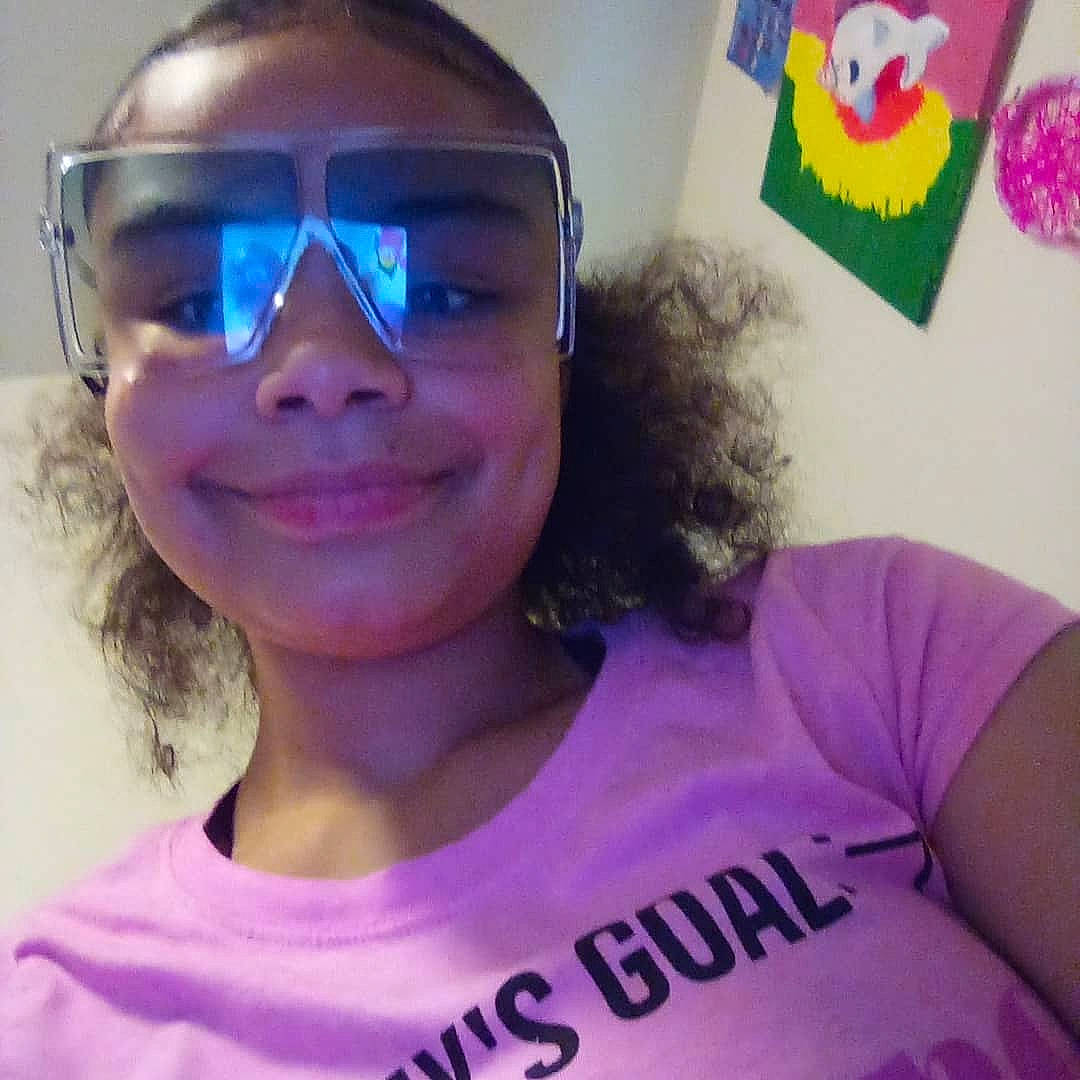 Makayla is registered to the contest to win money with this photo: chin, ear, eyebrow, facial_expression, forehead, glasses, goggles, hairstyle, jaw, joy, mouth, neck, nose, organ, person, purple, shoulder, skin, smile, sunglasses