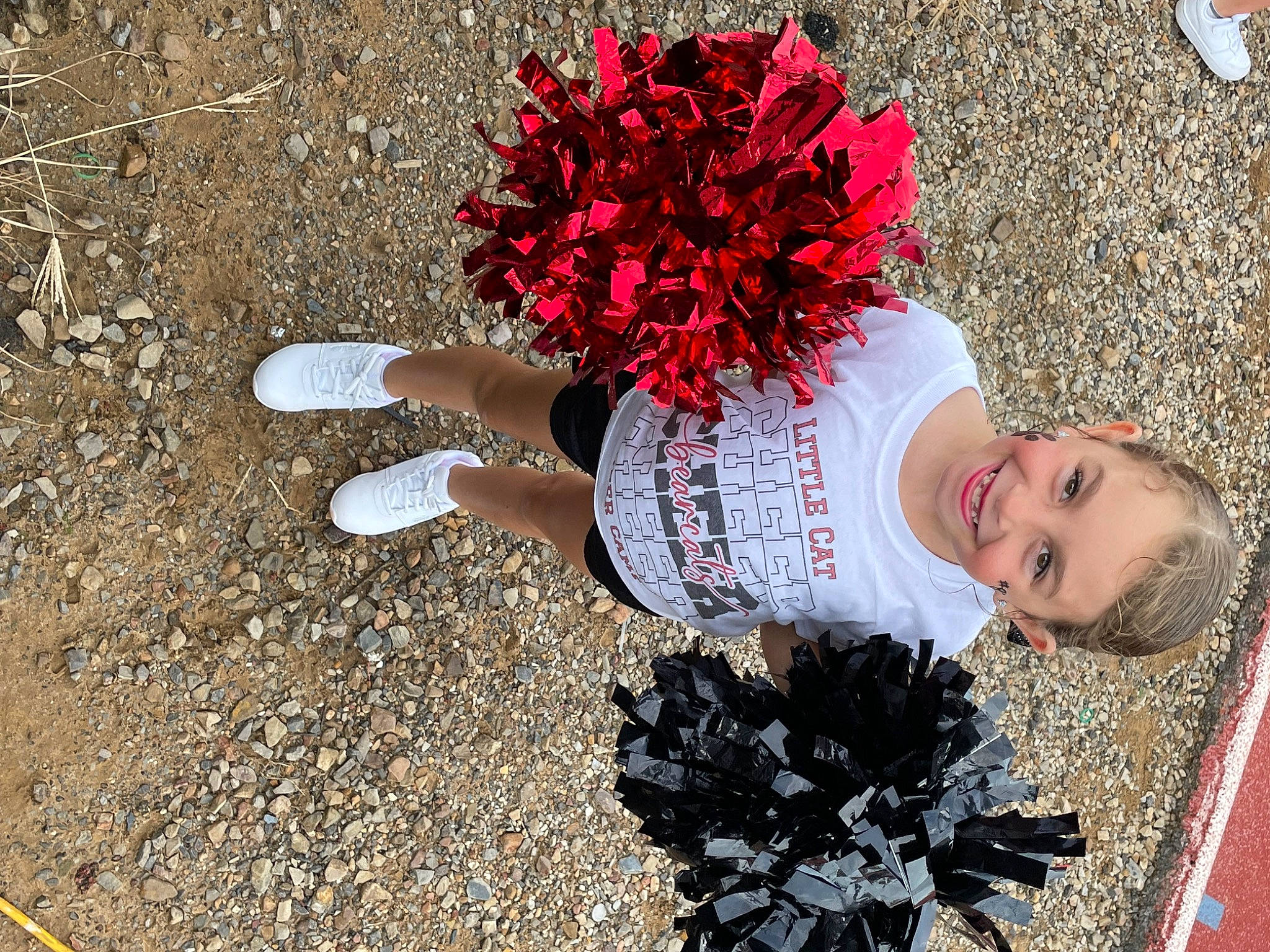 Sophi is registered to the contest to win money with this photo: asphalt, carmine, concrete, glove, grass, happy, human_leg, joy, people_in_nature, person, petal, plant, road_surface, shadow, sidewalk, smile, soil, tar, thigh